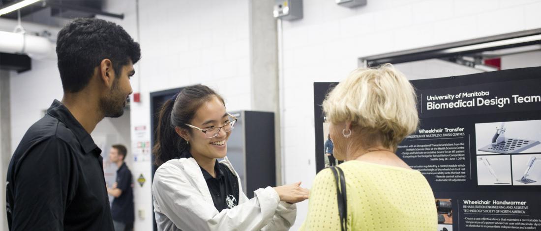 Students explaining their exhibit to a visitor.