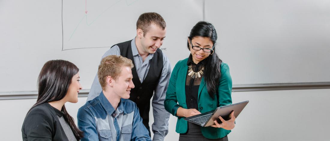 Four students work together at a table.