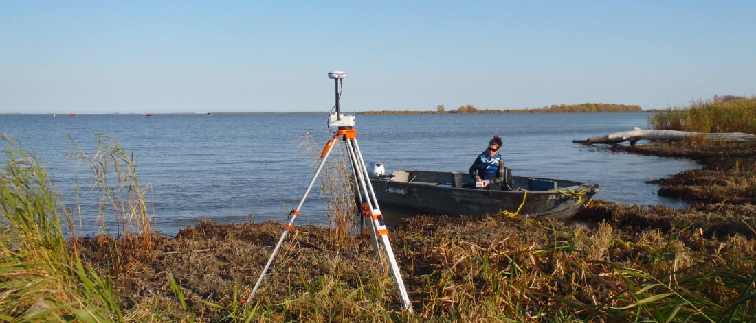 A civil engineer surveys a large river from a boat.