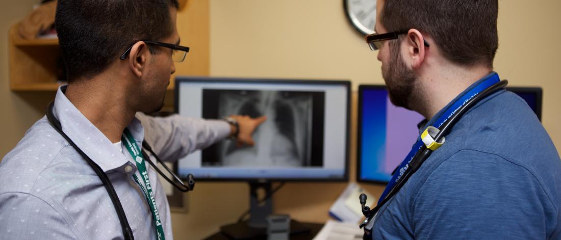 Two medical students look at a lung X-Ray on a computer screen