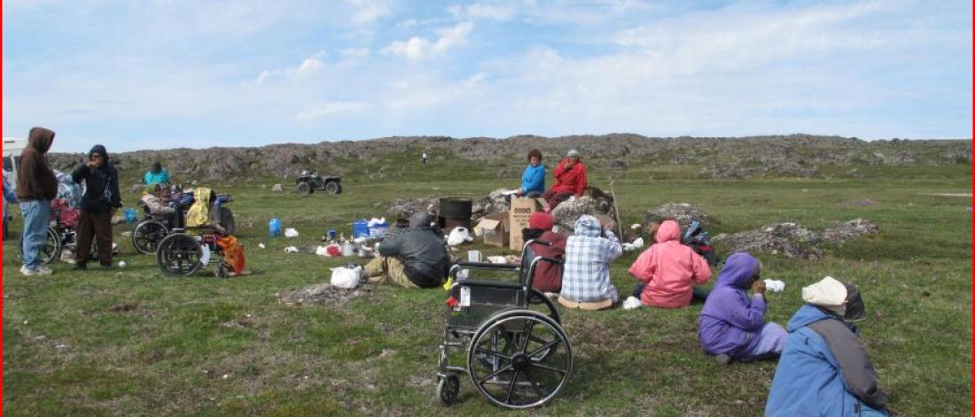 Indigenous group seated in a field.