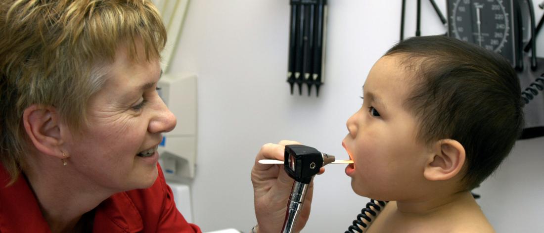 Physician checking a baby's mouth.