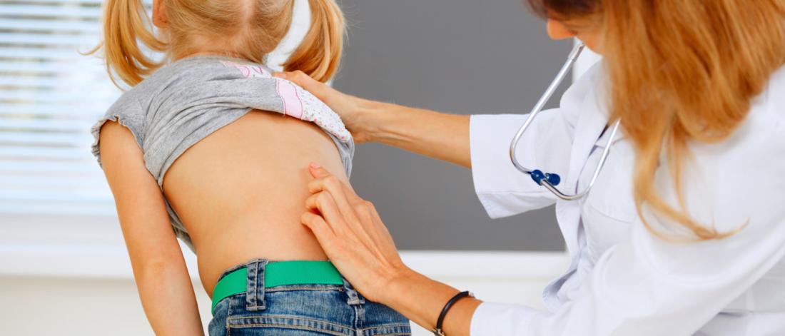 Little girl being examined for scoliosis.