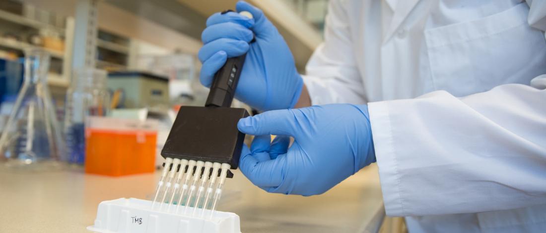 A lab technician works with a sampling device.