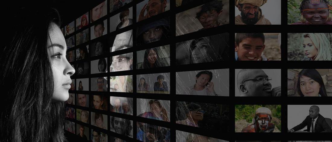 Woman looking at photos of different people of all ages and races.