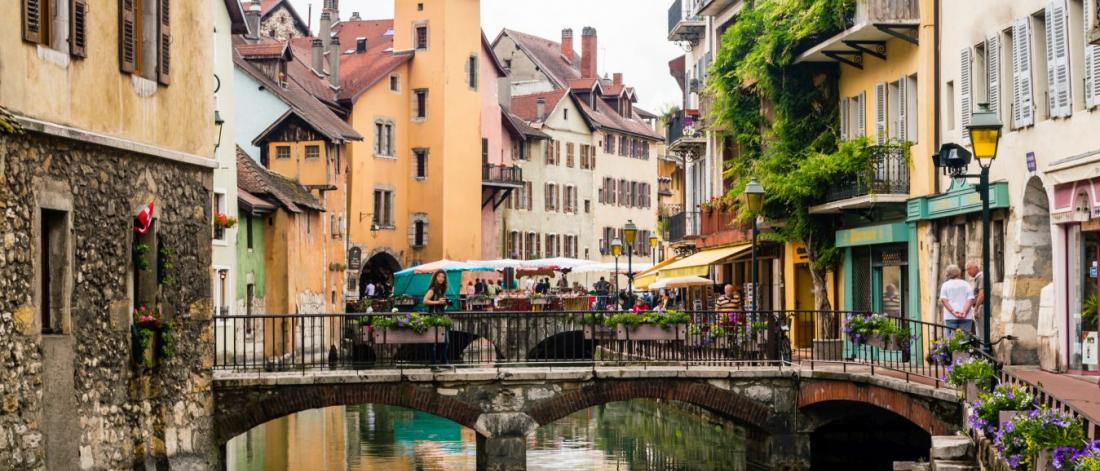 Streets, canal and river surrounded by cafe and european buildings.