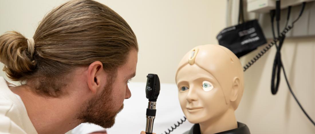 Student examines eye on practice mannequin 
