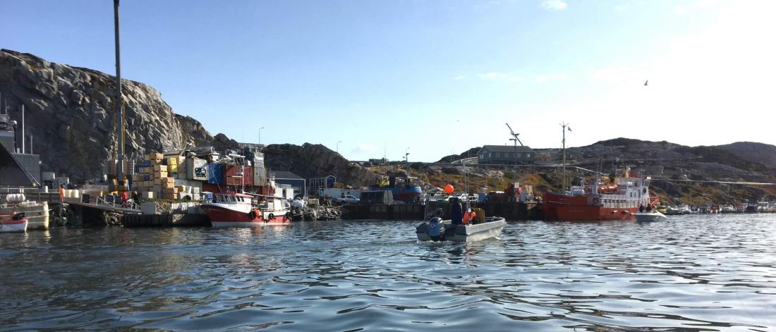 Colourful ships in the rolling water of the harbour at Ilulissat, Greenland.