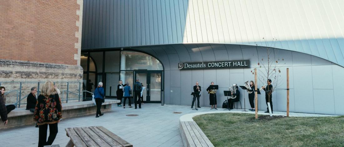 Musicians, academics, and visitors gather by the entrance of the Desautels Concert Hall.
