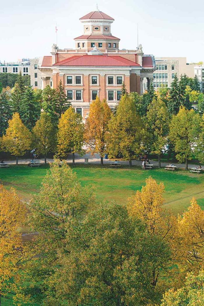 Panoramic view of Fort Garry Campus, including administration building surrounded by many trees starting to turn to fall colours.