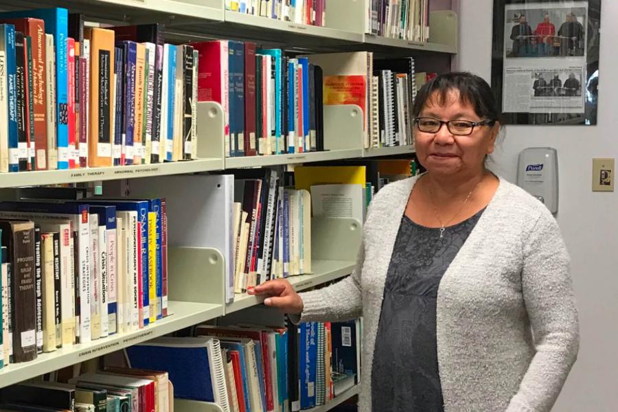 Elanor Welton standing inside the Northern Social Work Program library. 