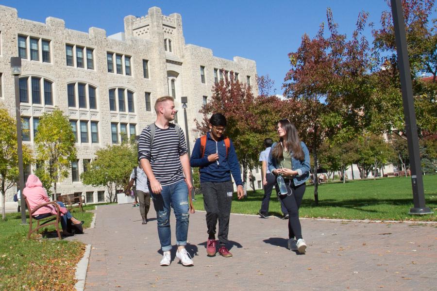  Three University of Manitoba students walk outdoors together at the Fort Garry campus.