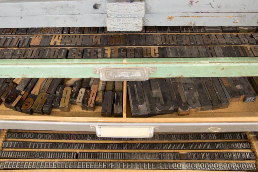 Trays full of organized of metal block printing letters, numbers and special characters.