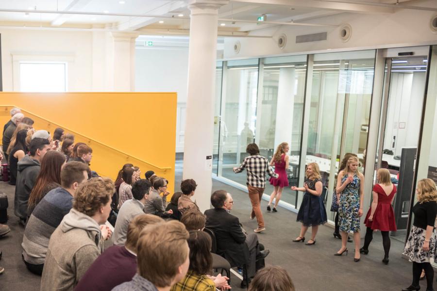 An audience fills the library concourse and watches a student group performance during the Desautels student scholarship reception.