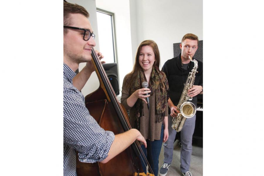 Three music students having a jam session with instruments in hand.