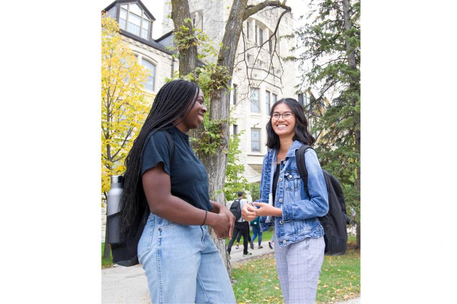 Two faculty of graduate studies students stand outdoors at the University of Manitoba Fort Garry campus.