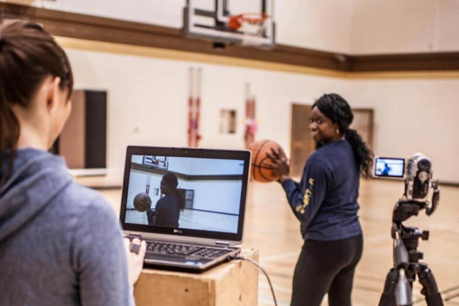 Two students doing research in a gymnasium.