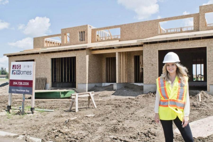 An architecture student stands in front of a partially built home for J and G Homes where she is participating in a co-operative integrated work program.