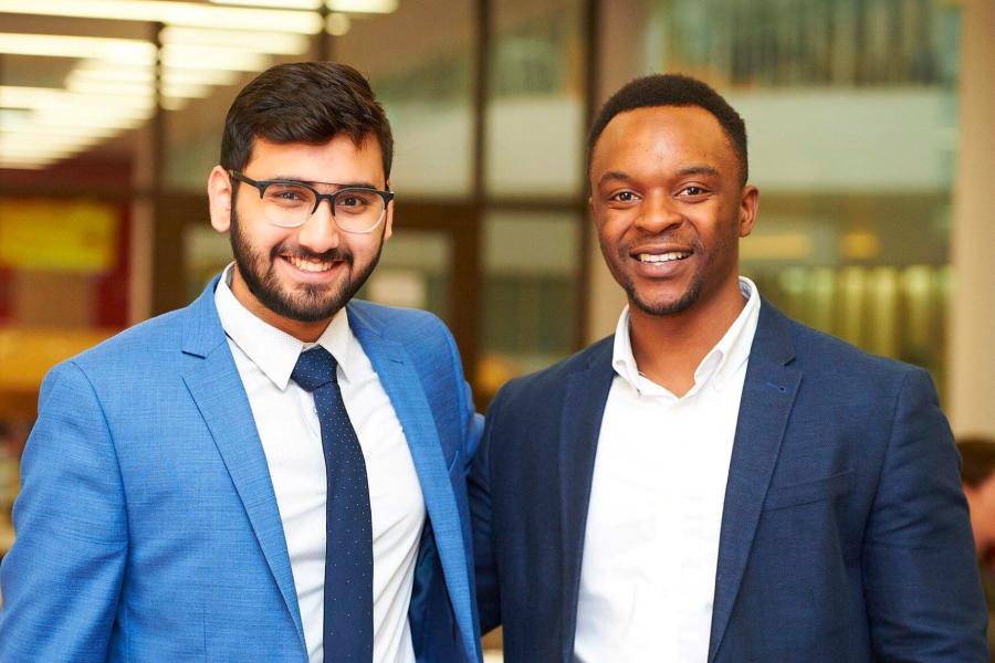 Two Asper Bachelor of Commerce students stand side by side smiling.