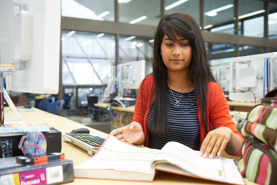 Asper School of Business student looking at a textbook.