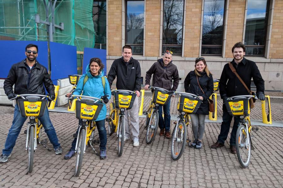 Group of people on their bikes, smiling for the photo.