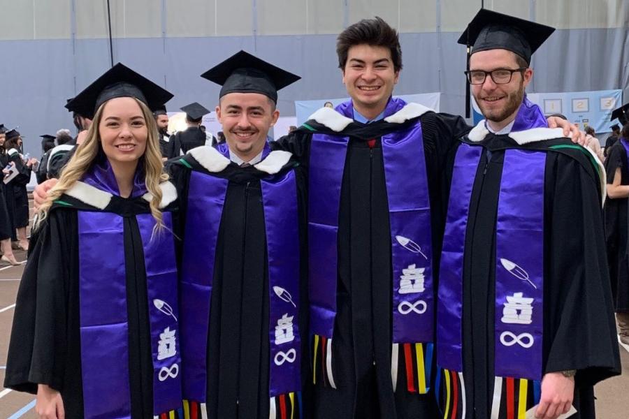 Four Indigenous Business Education Partner graduates stand together.