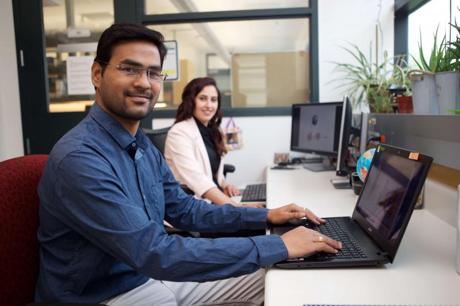 Two graduate students working at their computers