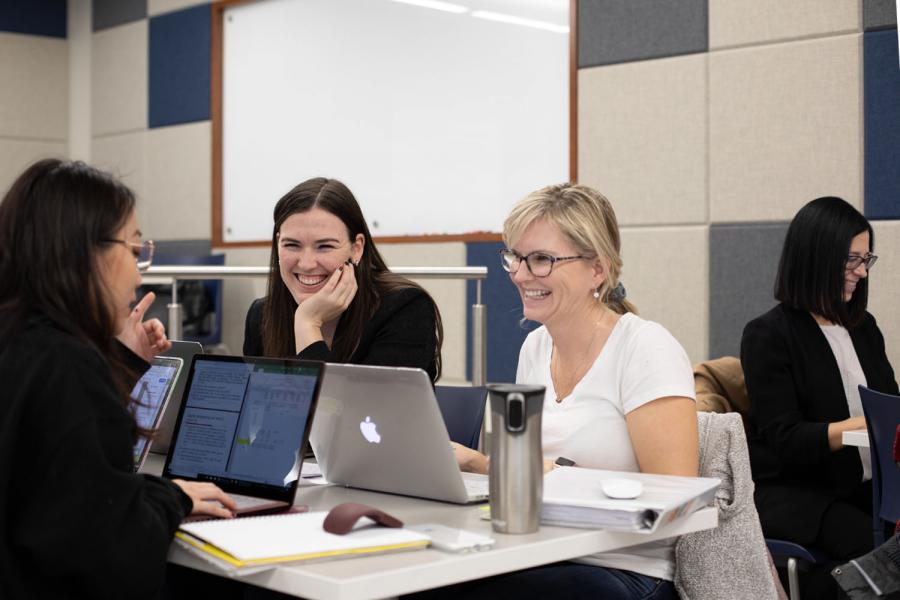 Asper Master of Business Administration students working on a project at a desk.