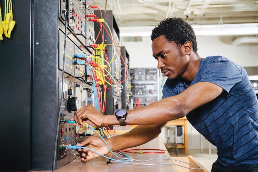 A computer engineering student works with some equipment. 