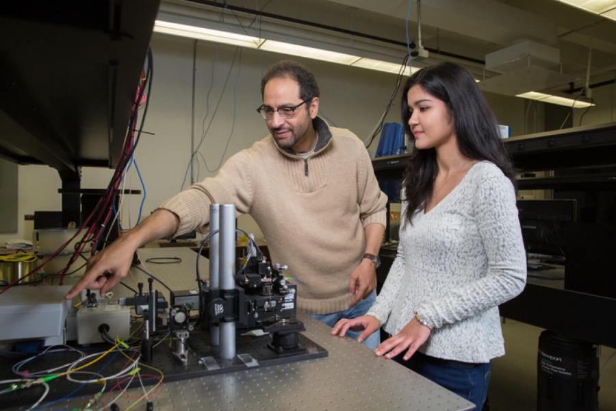 An electrical engineering student works in a lab with a professor.