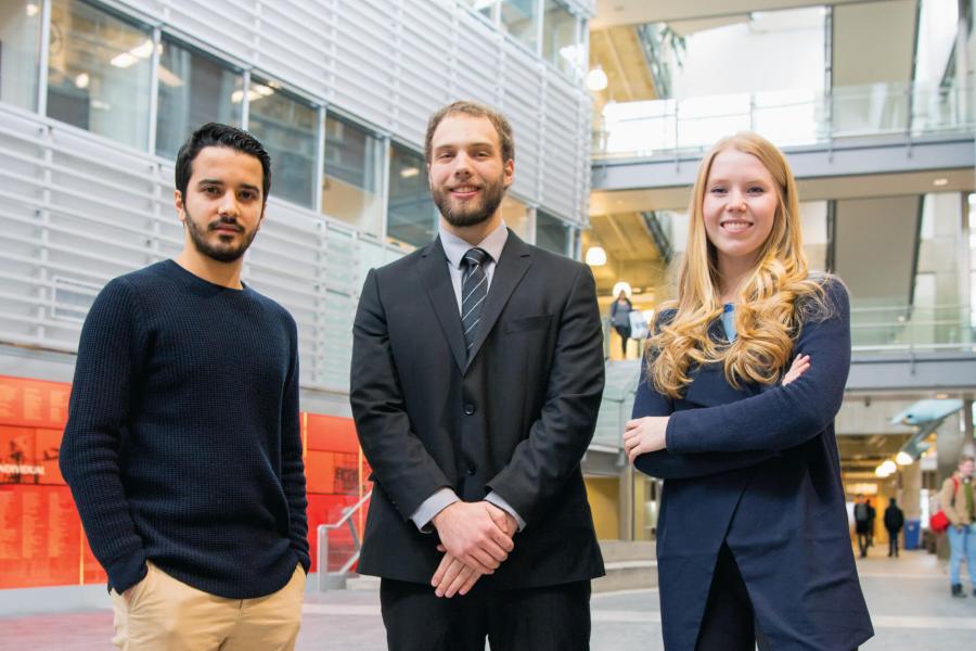 Three engineering co-operative education students stand together inside the engineering complex.