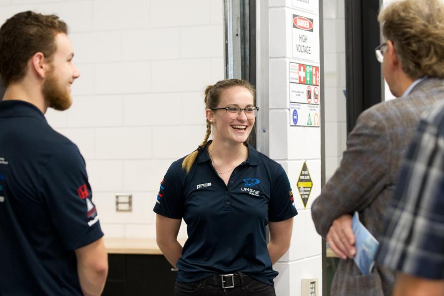 Engineering co-operative education students speak to a community member.