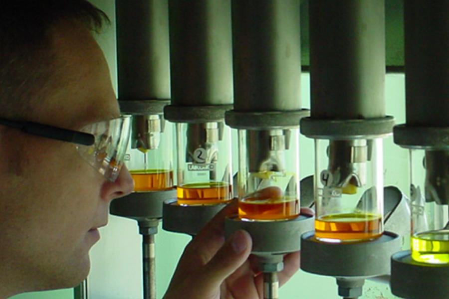 A researcher carefully inspects some biosystems engineering equipment.