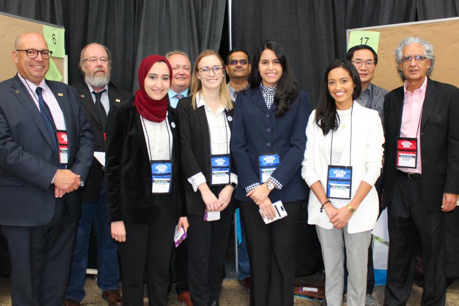 Dentistry students, professors and community members gather for a photo together during an event.