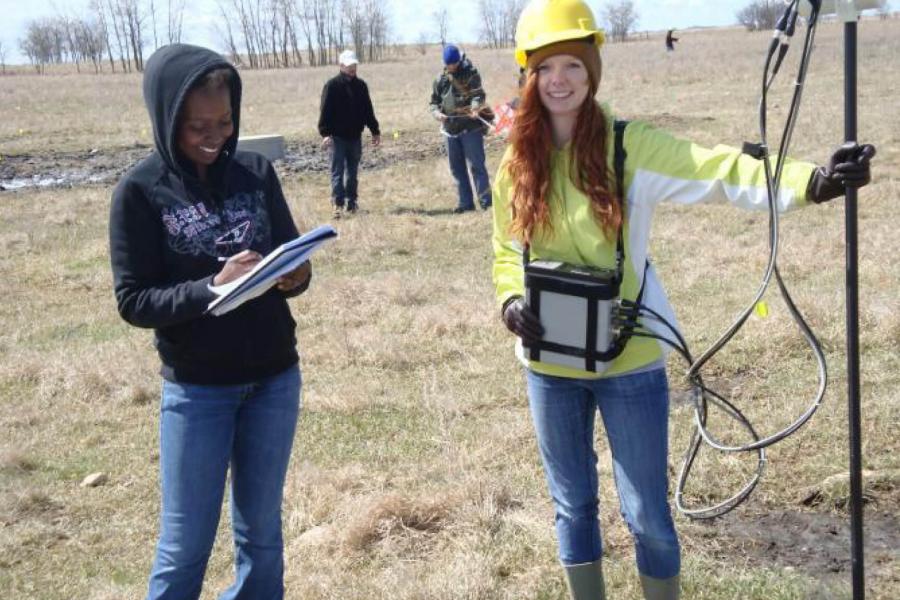 Geophysics students working in pairs to take measurements using various equipment.