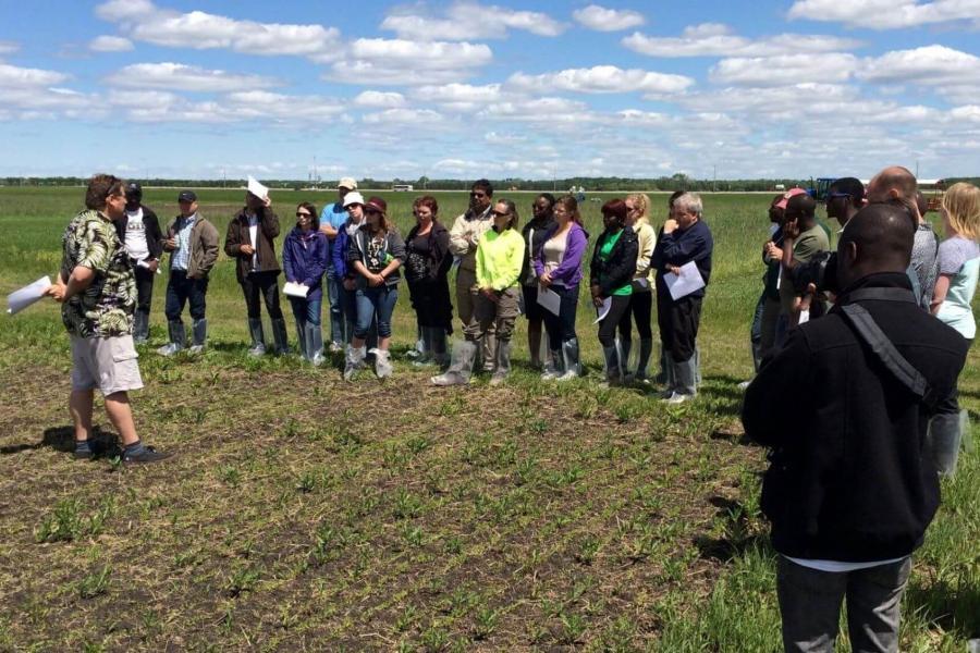 Community members gather in an open field during a community outreach program.