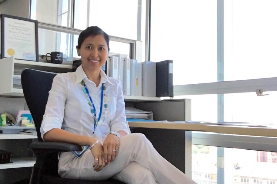 A student sits at a desk in a brightly lit office space during a co-op work placement.