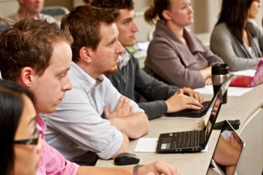 Law students seated side by side at a narrow curved table.