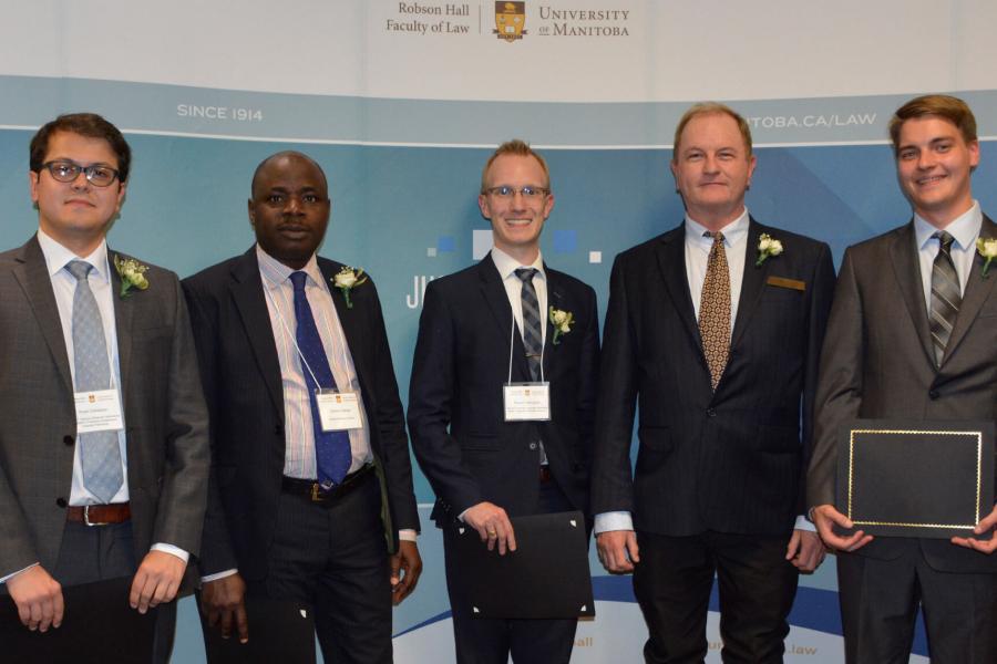 Five people stand side by side for a photo together, some hod certificates in their hands.