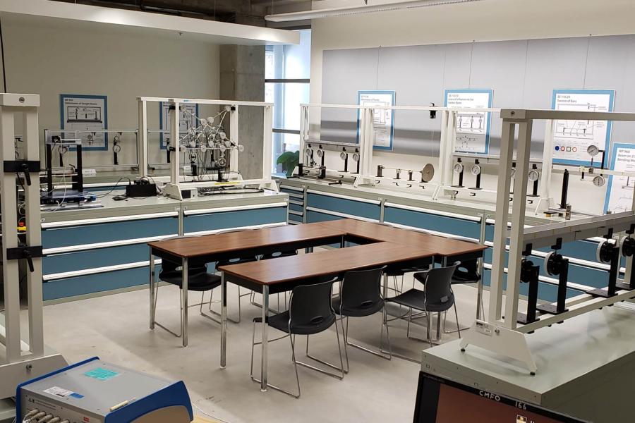 Inside the civil engineering mechanics lab. Three rectangular tables make a 'u' shape surrounded by various equipment.