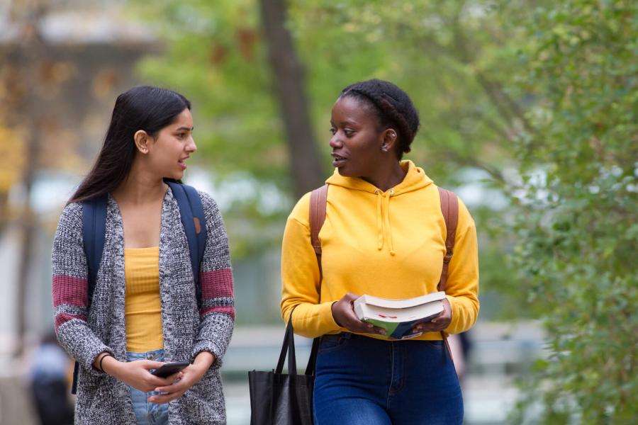 Two students walking together outdoors at the University of Manitoba Fort Garry campus.