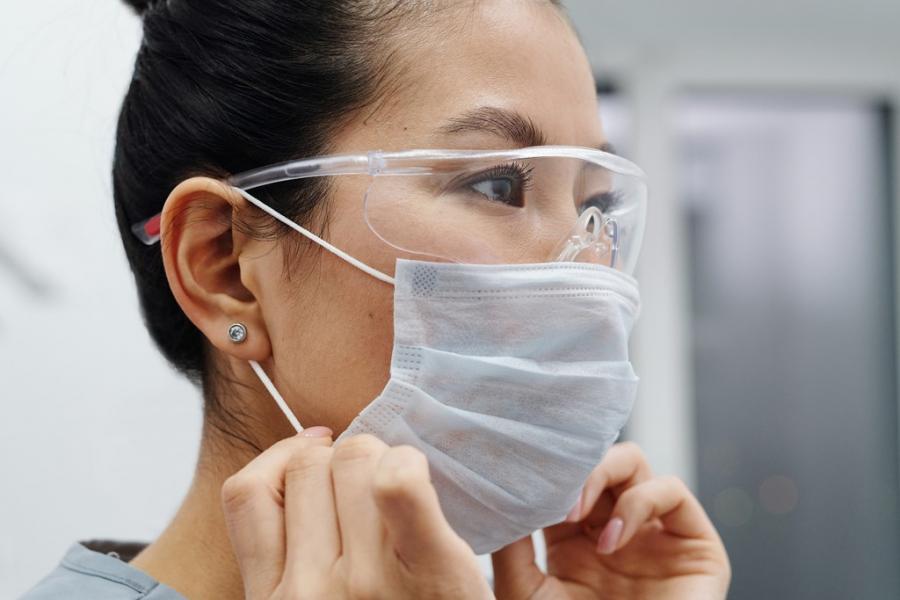 Researcher putting on a mask.