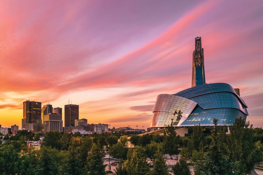 A picturesque sunset view of the downtown Winnipeg skyline featuring the Canadian Museum for Human Rights. 