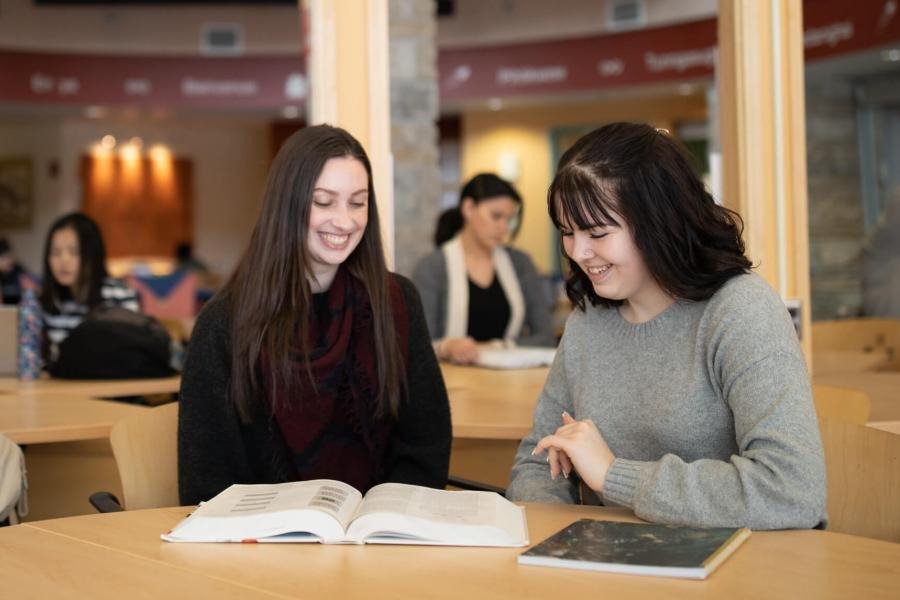 Two students study together inside Migizii Agamik.