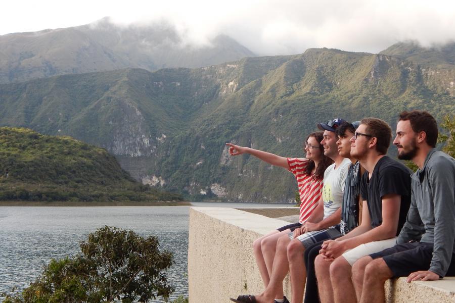 Five students seated side by side overlooking a scenic view of Ecuador.
