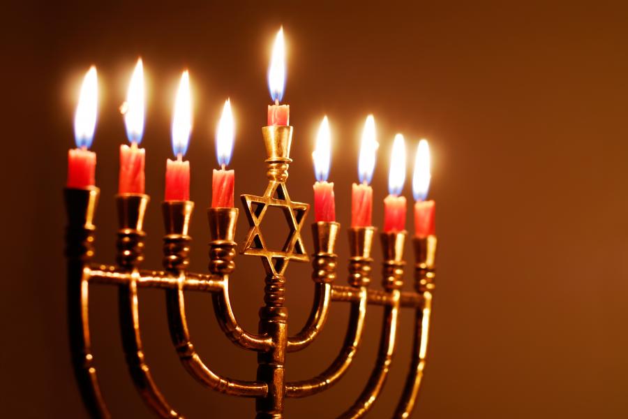 Golden menorah with red candles burning.