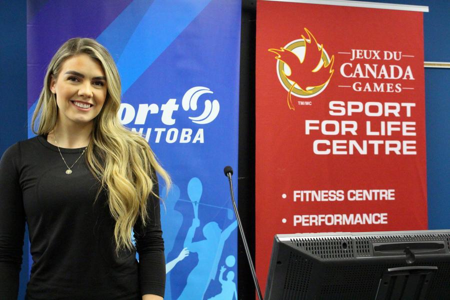 Student standing in front of banner that reads Sports for Life.