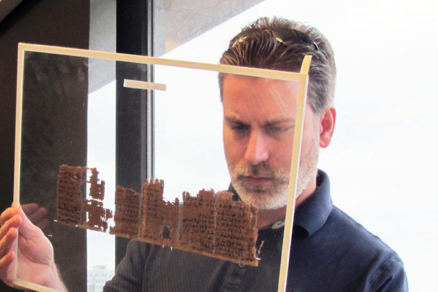 A researcher examining papyrus.
