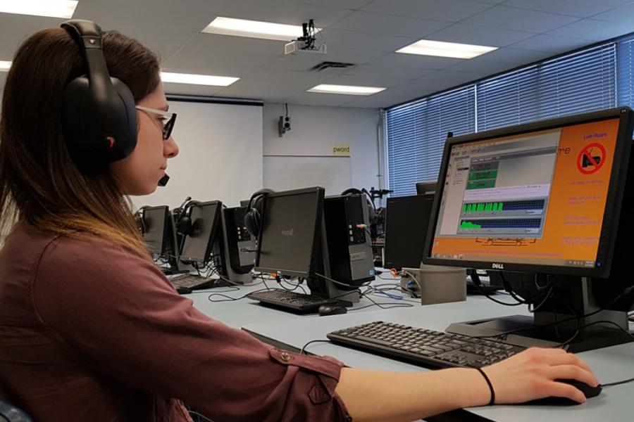 Student with headset on working at computer in Language Lab.