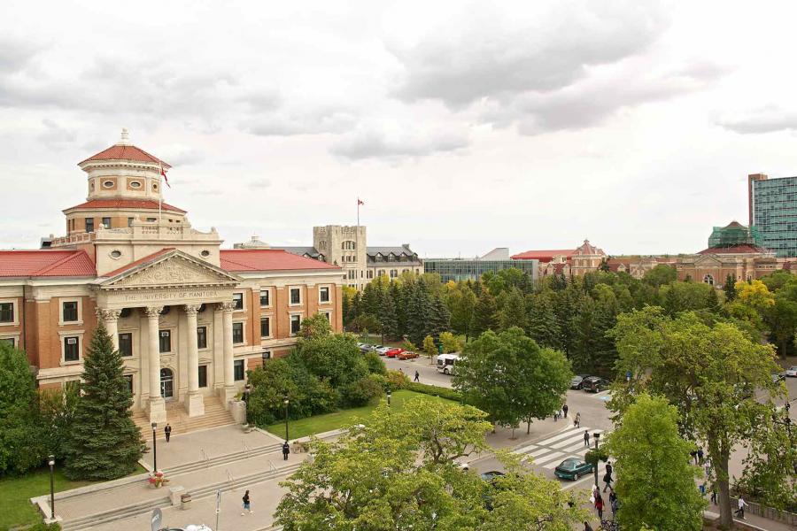 The UM admin building. A large red brick and limestone building with four ornate pillars on a staircase leading to the front entrance.